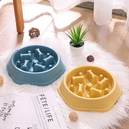 Ciotole anti-ingozzamento BellaDoggy blu e gialla appoggiate su un tappeto in ambiente domestico